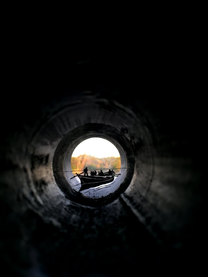 People Riding Canoe Boat View From Inside Pipe