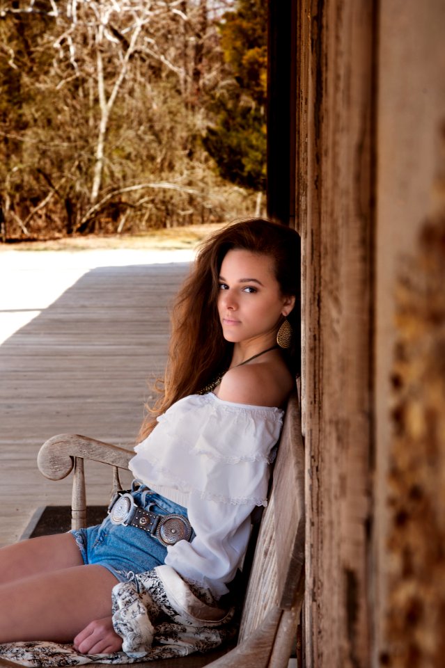 Woman Wearing White Off Shoulder Top Sitting On Bench photo