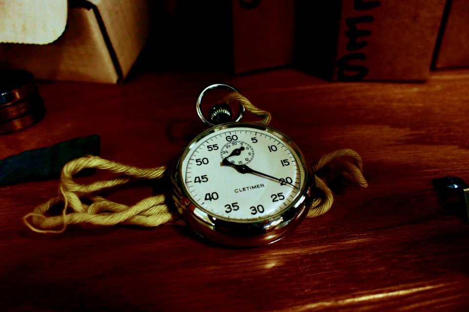 White Pocket Watch With Gold-colored Frame On Brown Wooden Board