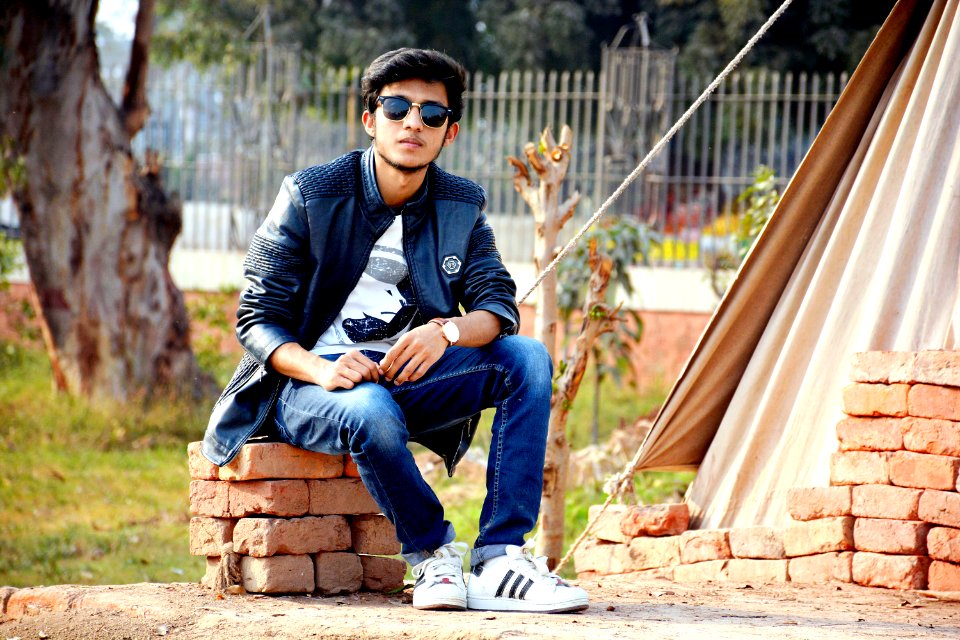 Man Wearing Sunglasses Sitting On The Concrete Bricks