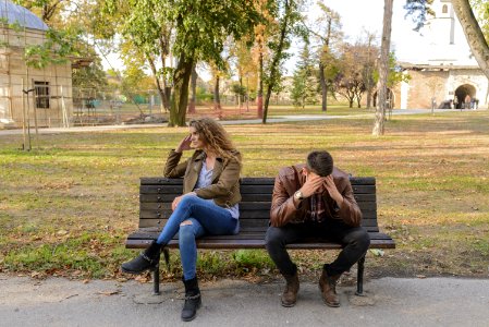 Woman And Man Sitting On Brown Wooden Bench photo