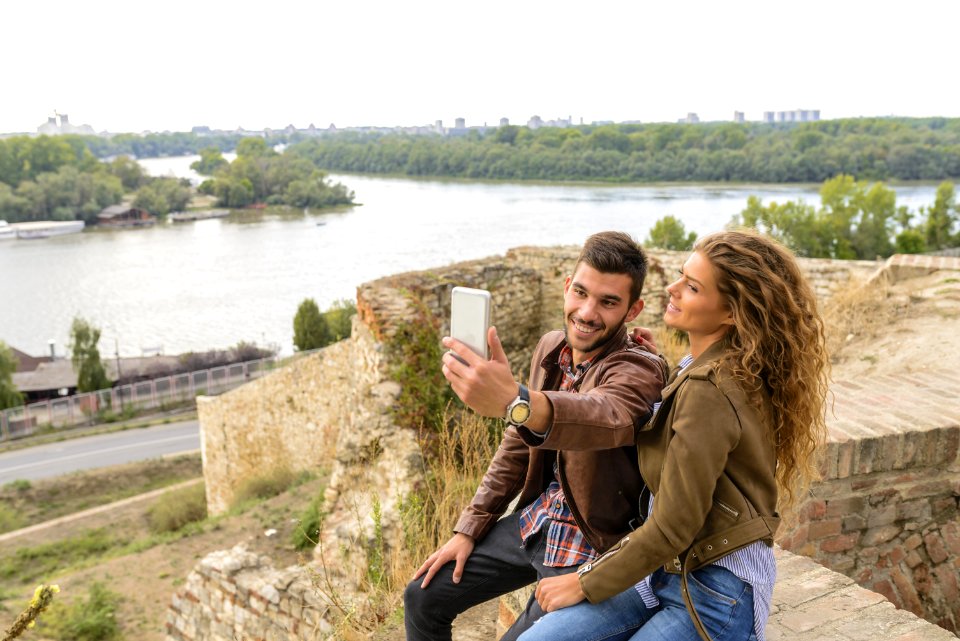 Woman And Man Sitting Against Body Of Water
