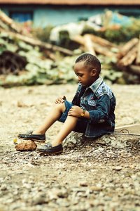 Boy Wearing Denim Jacket And Shorts With Pair Of Shoes photo