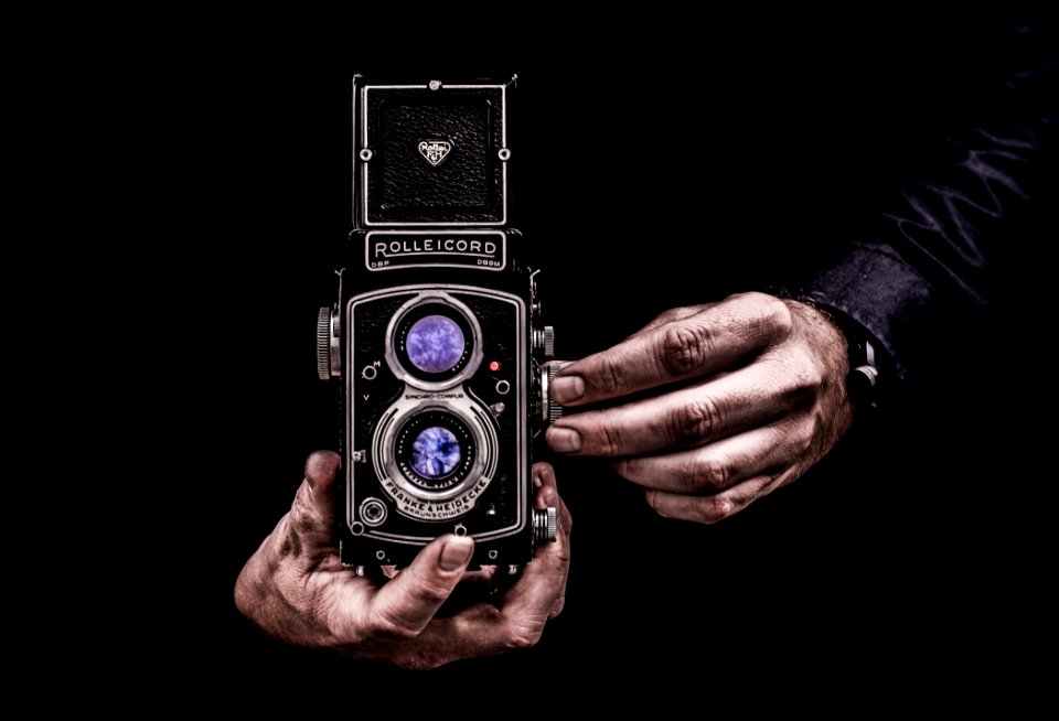 Person Holding Black Twin-lens Reflex Camera