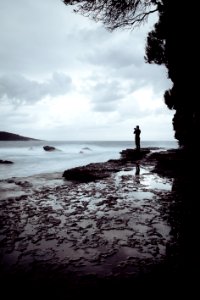 Man Standing On Rock Near Ocean photo