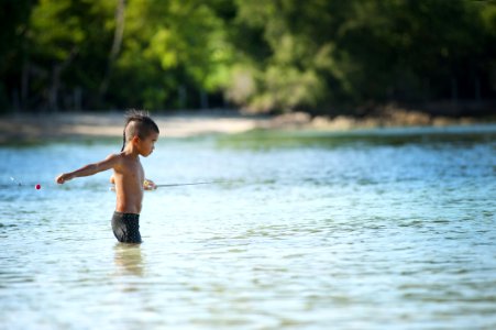 Topless Boy Wearing Black Shorts Standing On Bodies Of Water
