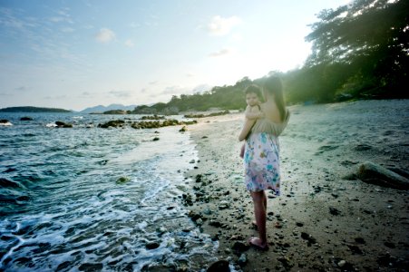 Woman Carrying Baby Beside The Seashore photo