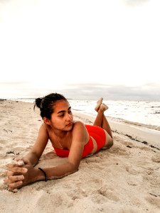 Woman Wearing Red Bikini Laying On Beach Sand photo