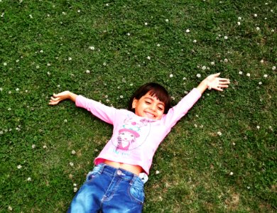 Girl Laying On Green Grass photo