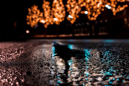 Selective Focus Photography Of Asphalt Road With Water Droplets Near City Lights During Nighttime photo