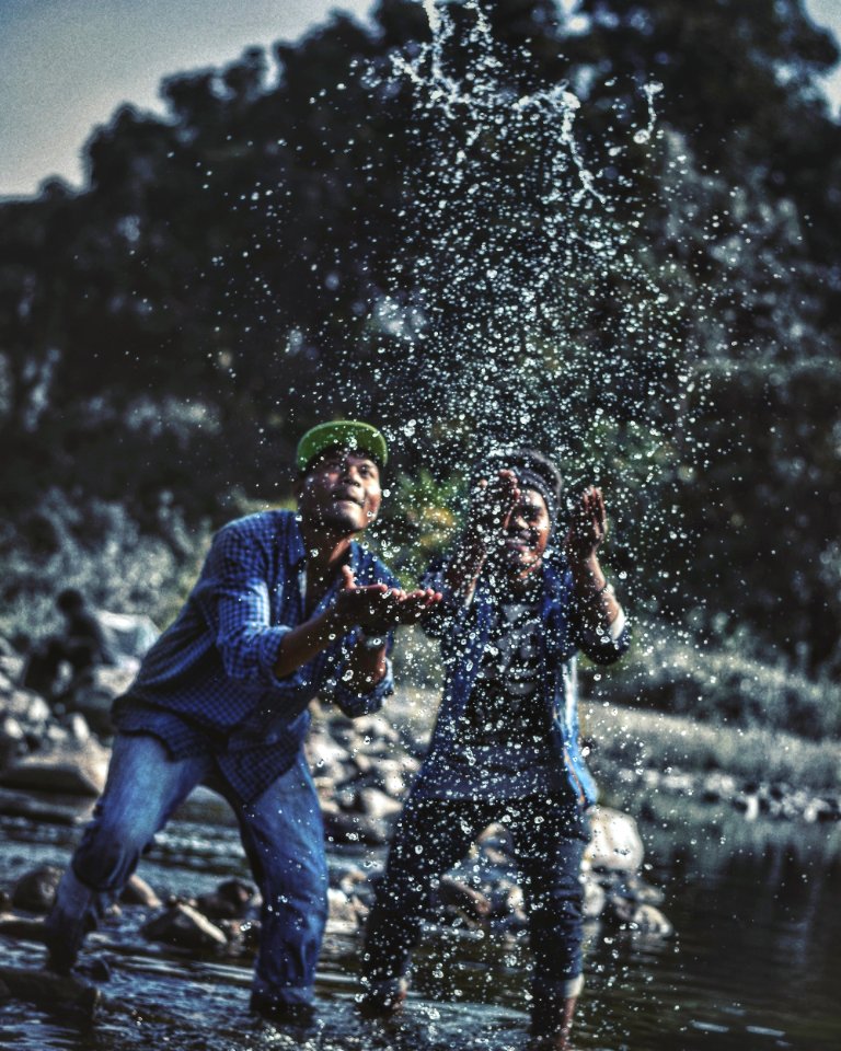 Two Men Playing With Water In Lake