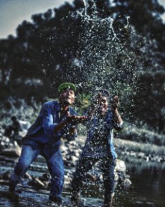 Two Men Playing With Water In Lake