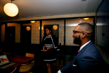 Man In Blue Formal Suit Jacket Sitting Near Standing Woman