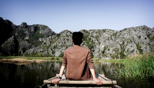 Man Sitting On Bridge Front Of Mountain photo