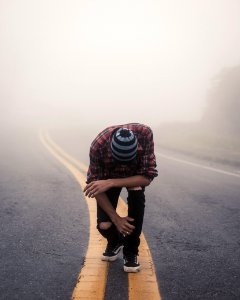 Man Wearing Red Plaid Shirt Standing In Center Road photo