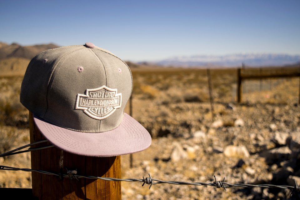 Gray Harley-davidson Motorcycles Flat-brimmed Cap Hanged On Brown Wooden Fence With Gray Barb Wires