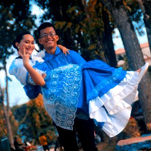 Man Wearing Blue Button-up Shirt Carrying Woman photo