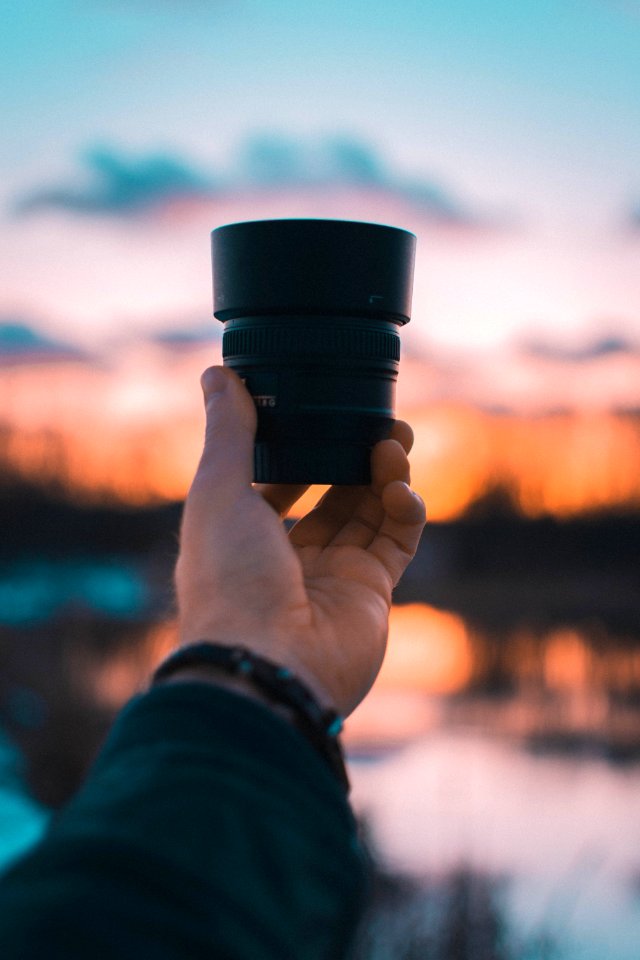 Close-Up Photography Of A Person Holding Camera Lens
