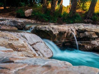 Photography Of Water Flow Near Rocks photo