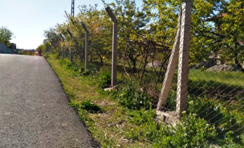 Gray Concrete Pavement Near Gray Wire Fence photo