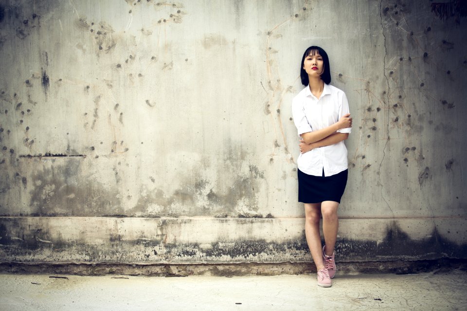 Woman Standing Next To A Wall