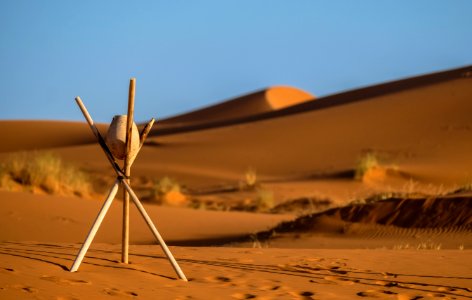 Brown Stone On Tripod Sticks At A Desert