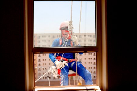 Man Wearing Orange Safety Strap In Front Of A Windowpane