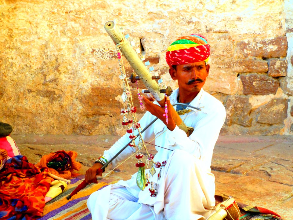 Man In White Long-sleeved Thawb Holding A Musical Instrument