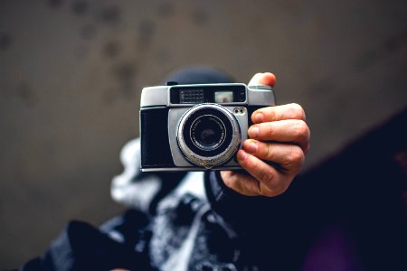 Person Holding Gray And Black Slr Camera photo