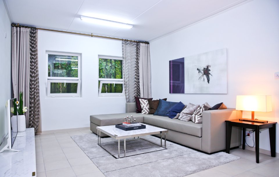 Gray Fabric L-shape Sofa And Assorted-color Throw Pillows In White Living Room