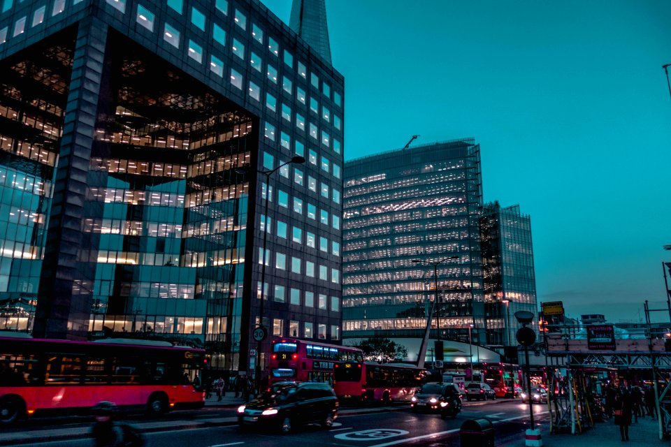 Vehicles Passing Near Two Black High-rise Building Under Blue Sky
