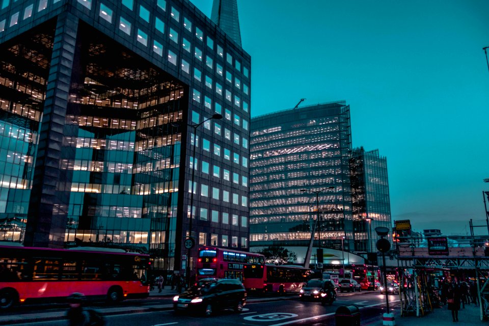 Vehicles Passing Near Two Black High-rise Building Under Blue Sky photo