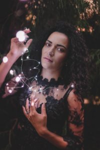 Photography Of A Woman Holding String Lights photo
