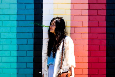 Woman Wearing White Cardigan Standing Beside Multicolored Wall photo