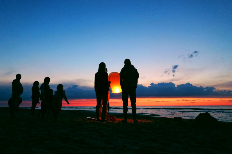 Silhouette Of People By The Sea photo