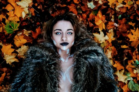 Woman In Black Fur Coat Laying On Brown Maple Leaves