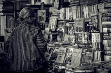 Grayscale Photography Of Woman Looking At The Books photo