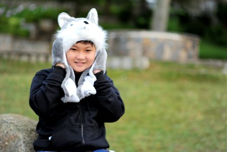 Kid Wearing Gray Wolf Critter Hat And Black Jacket photo