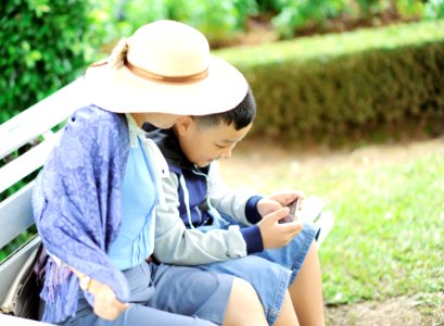 Woman With A Boy Sits On Bench photo