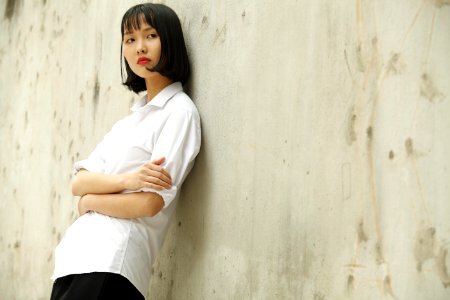 Woman Leaning On Concrete Wall photo