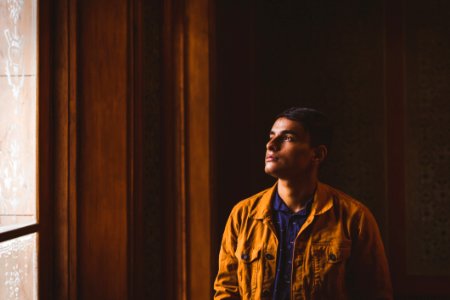 Photo Of Man Looking Towards Window photo