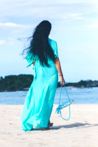 Woman In Teal Dress Standing On Beach