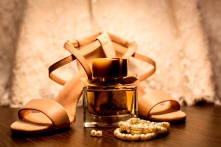 Brown Glass Fragrance Bottle Beside White Pearl Bracelets photo