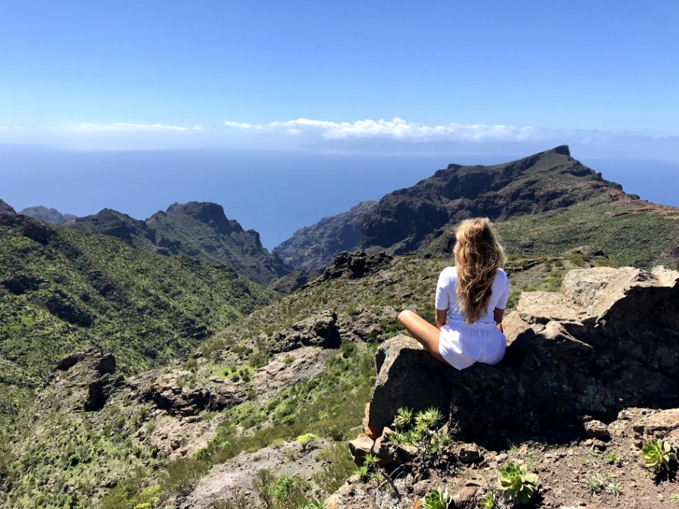 Woman In White Top Sitting On Rock
