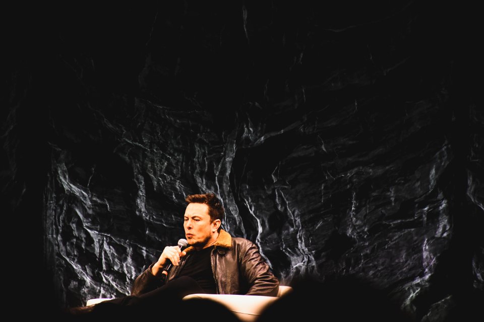 Man Wearing Brown Bomber Jacket Holding Microphone