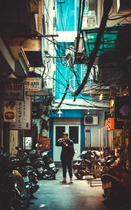 Man Standing On Concrete Road With Parked Motorcycles While Holding Dslr Camera photo