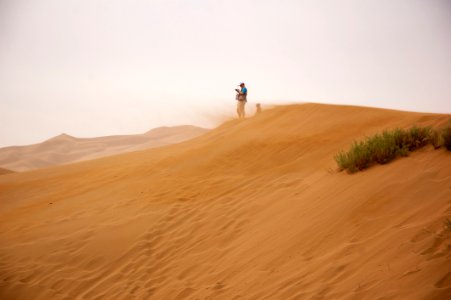 Man Standing On Brown Sand Under Gray Sky photo