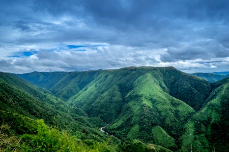 Landscape Photography Of Green Mountains Under Cloudy Sky photo