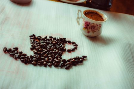 Brown Coffee Beans Beside Ceramic Mug On Table photo