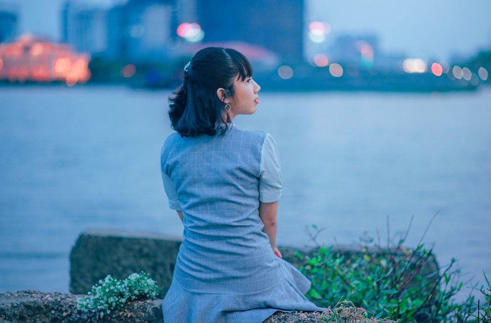 Woman Wearing Gray Dress Sitting Near Body Of Water photo